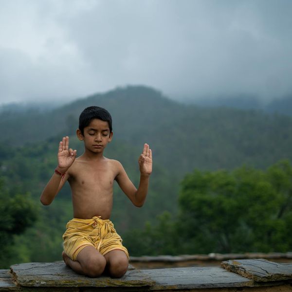 Child balancing on one leg in a yoga pose, showing focus and stability.