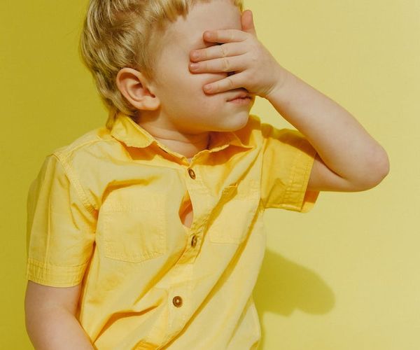 Happy child doing a simple yoga pose in a bright, playful studio.